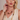 A blonde woman wearing a matching jewelry set with chunky gold and cream-colored chain necklaces, matching drop earrings, and a bracelet, styled with a cream-colored sleeveless top against a soft beige background.