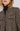 Close-up of a woman wearing a brown tweed jacket over a dark brown turtleneck, showing the textured fabric and decorative buttons.