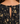 Close-up of the back of a black dress with a beige and yellow floral pattern and a central tie-back closure.