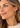 Model wearing two tone knotted pin drop earring