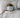 A child lying in bed under a light gray blanket, with a light blue textured eye mask covering the eyes.