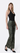 model wearing olive green jeans with black tank top with white background
