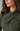Close-up of a woman wearing a draped olive green long-sleeve top, showing the texture and fit of the fabric.