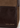 Close-up of a Katie Loxton handbag showing a dark brown textured leather panel with gold brand lettering, stitched seams, and a contrasting medium brown suede-like section.