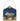 A decorative hanging wall plaque featuring a nativity scene with a baby in a wooden manger under a dark blue starry sky, with a gold star ornament at the top and a gold hanging loop.