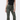 model wearing olive green floral jeans with black tank top on white background
