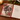 An open decorative notebook on a wooden table, featuring a winter horse illustration on the cover and lined paper inside with the phrase 'Big dreams brighter days and a grateful heart heart'. A lit candle, evergreen branches, and red berries are visible around it.