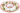 A white ceramic holiday serving platter with a scalloped edge, featuring a red rim and a printed wreath pattern of green holly leaves, red berries, and light blue accents.