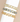 Three gold-plated bangle bracelets with oval cabochon gemstones, displayed stacked on a white cylindrical stand against a beige background.