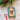 A rectangular Christmas ornament or plaque with a teal-green border and a vintage Santa illustration, tied with a red ribbon and tassel, placed on a light stone surface with pine branches and red berries at the top.