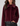 A woman wearing a plush, cropped faux fur jacket in deep burgundy with a wide collar, paired with black leather pants, against a solid light gray background.