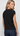 A woman wearing a black sleeveless knit top with side drawstrings, shown from the back against a light gray studio background.