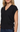 A close-up of a woman wearing a black knit V-neck sweater vest with cap sleeves, side ruching, and drawstring ties at the hem, paired with blue jeans against a plain light background.