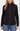 A woman wearing a black ribbed knit zip-front jacket with a quilted cable-knit front panel and dark shoulder panels, paired with blue jeans, against a plain light background.