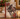 A decorative book or journal with a vintage-style Christmas horse cover sits on a wooden table, styled with a candle, books, and evergreen branches.