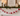 A festive holiday garland with red and white pom-poms and candy-cane motifs draped across a white fireplace mantel.